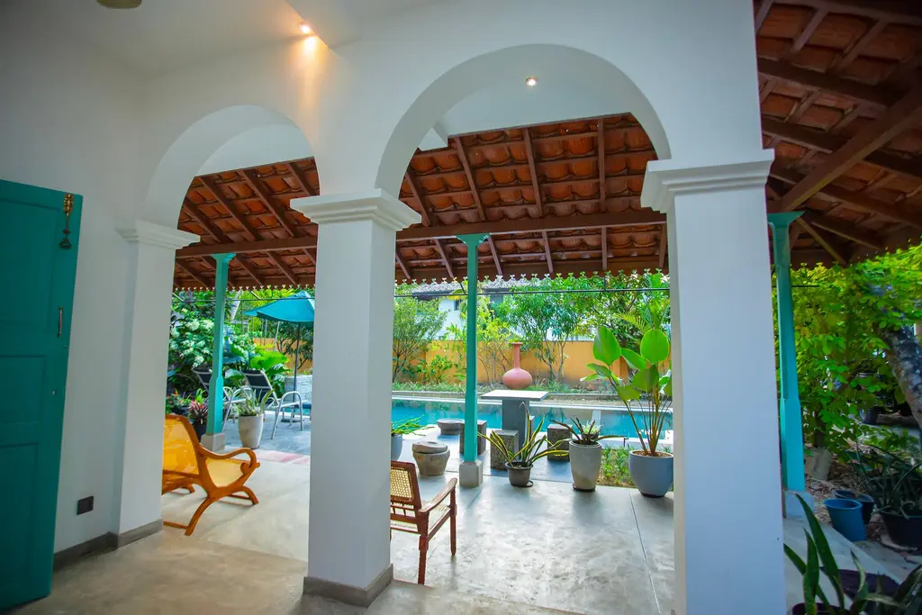 White arched colonnade opening onto the pool and garden