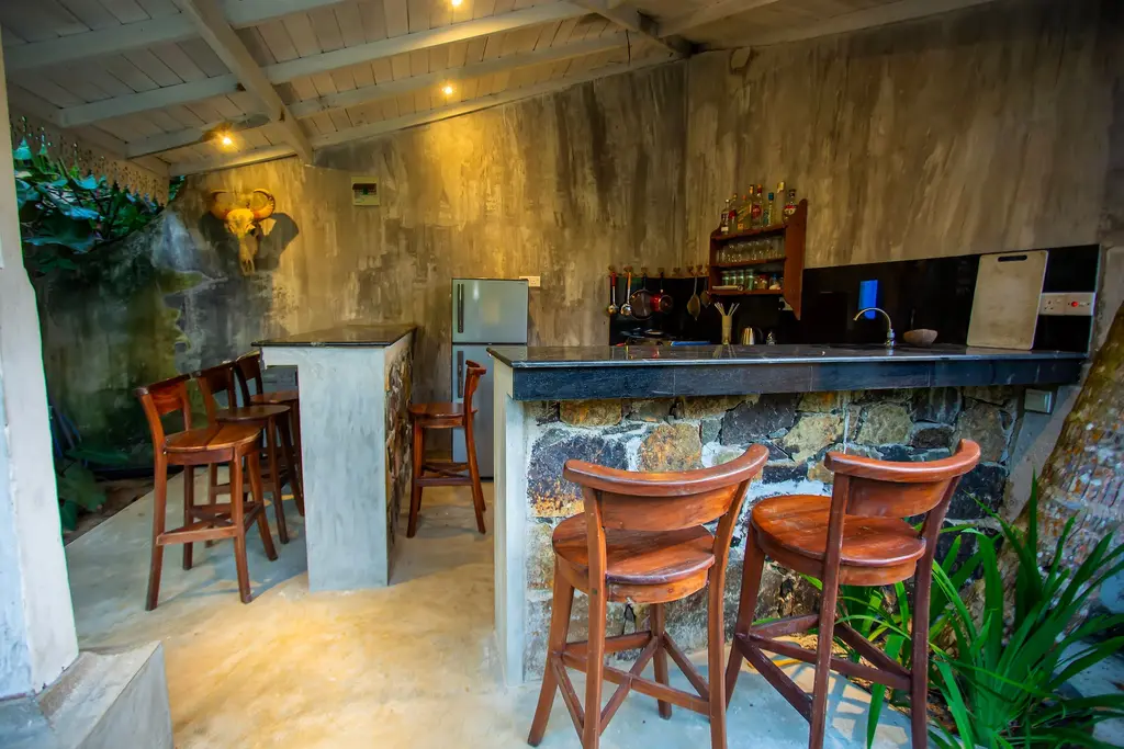 Bar counter with high stools against a stone feature wall