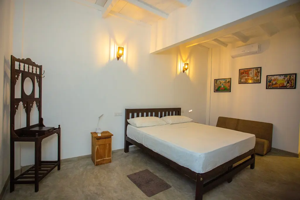 Double bedroom with local artwork and a carved timber chair