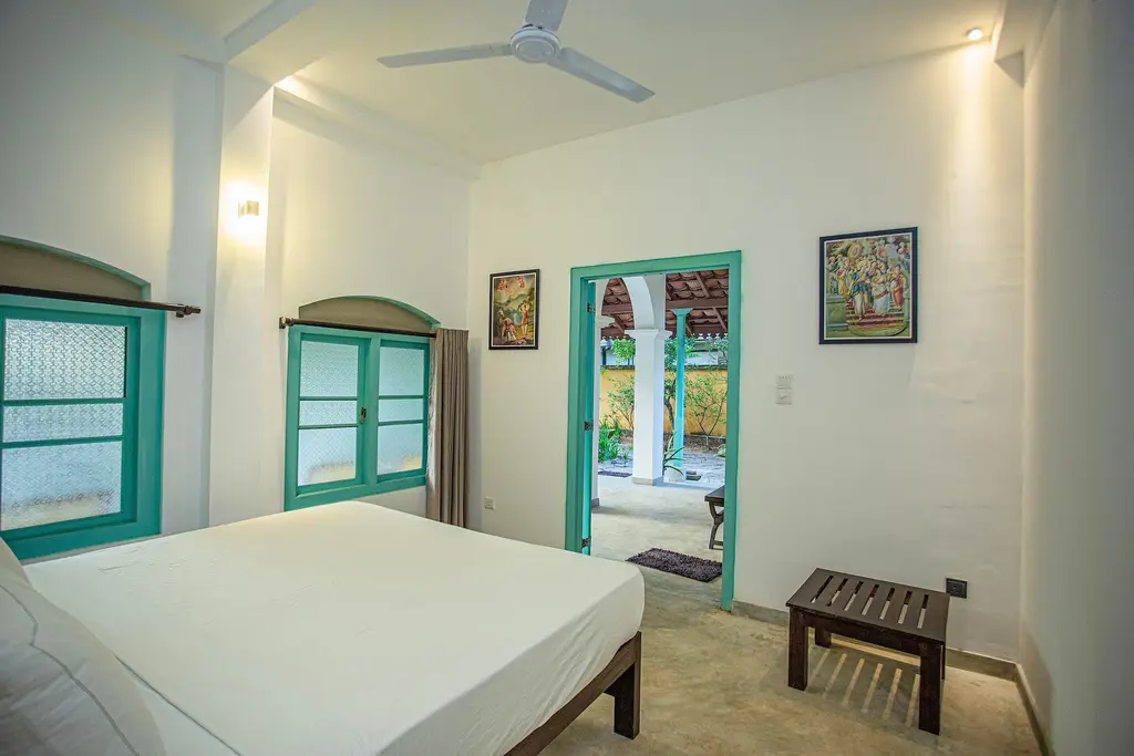 Bedroom with a ceiling fan, artwork and a door to the balcony