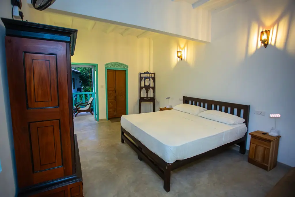Bedroom with an antique timber wardrobe, a double bed and turquoise doors