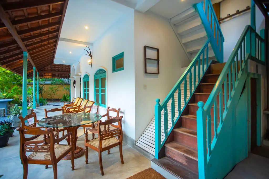 Turquoise timber staircase beside the veranda dining area