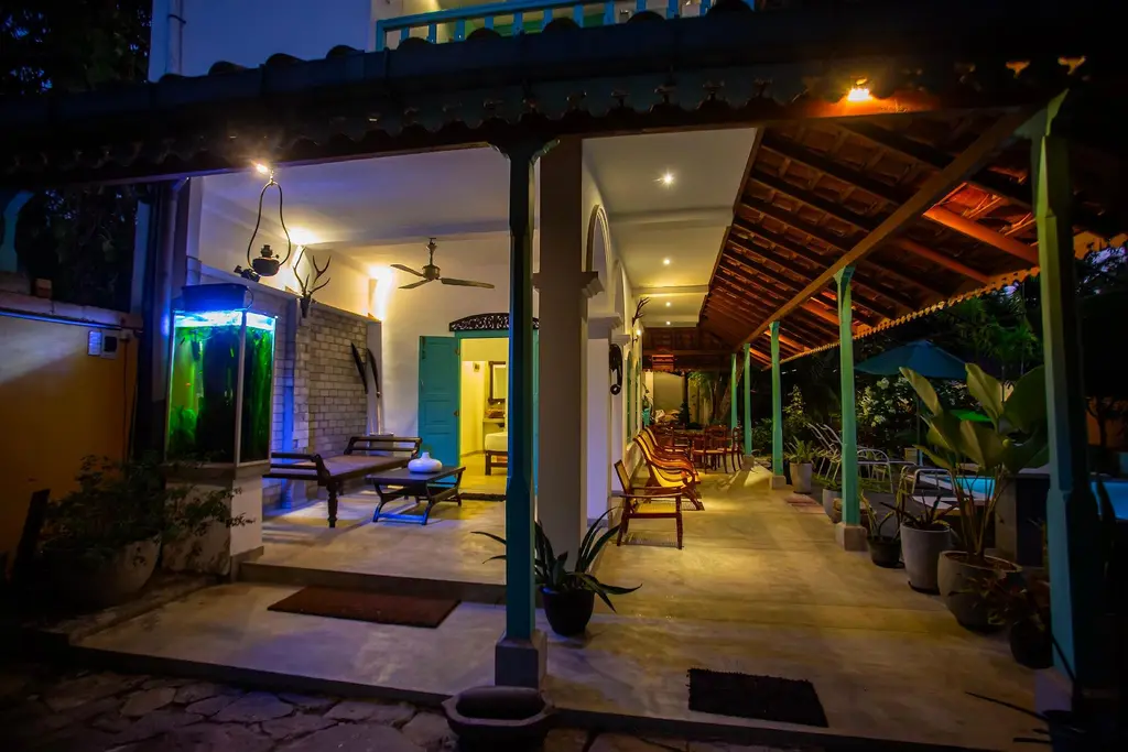 Long tiled veranda with turquoise pillars, lit in the evening